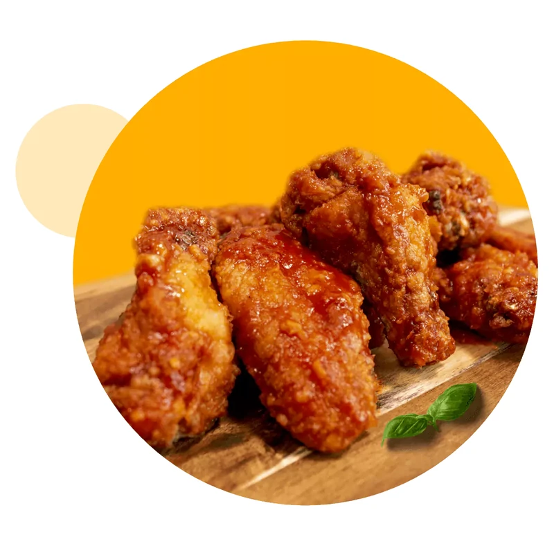Jumbo chicken wings tossed in sauce at Queen's Pizza & Wings in Hamilton, ON