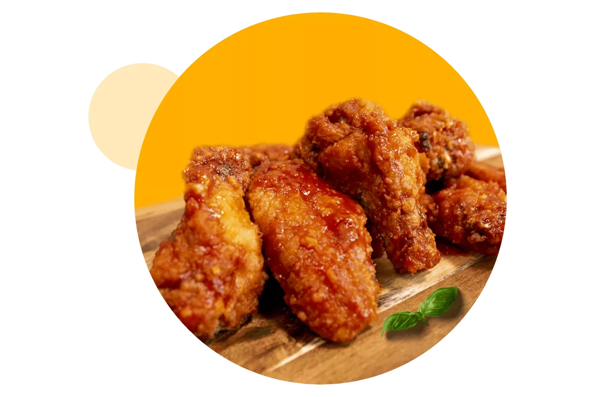Jumbo chicken wings tossed in sauce at Queen's Pizza & Wings in Hamilton, ON